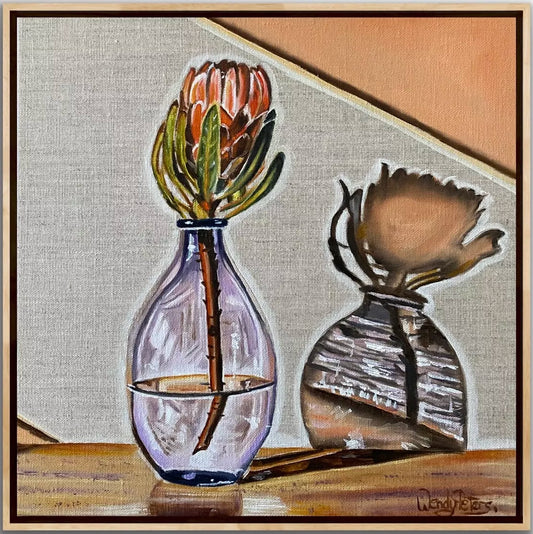 Purple Haze by Wendy Peters A Framed artwork depicting a purple glass vase with a pink protea flower, the vase creating amazing shadows on the wall behind.