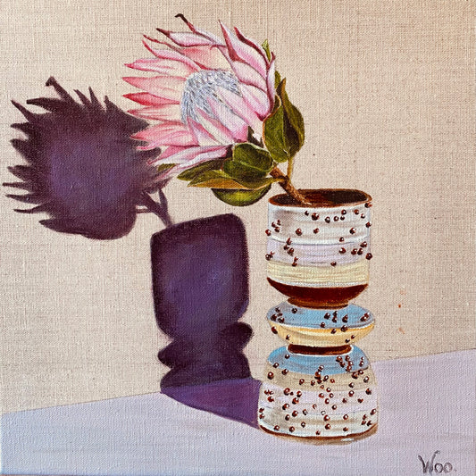 Painting of a single pink protea flower in a dotty striped pottery vase, by wendy peters